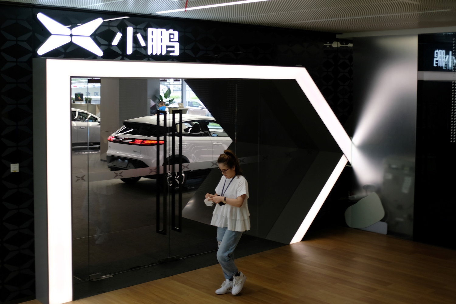 A woman walks by an Xpeng Motors showroom at its headquarters in Guangzhou, Guangdong Province, China