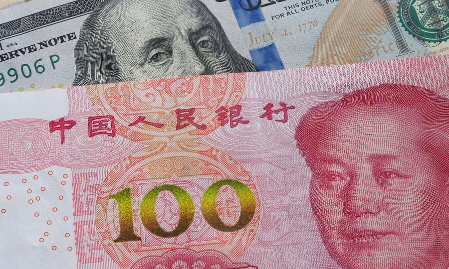 A 100 yuan/RMB note is seen with the US dollar. Photo: AFP