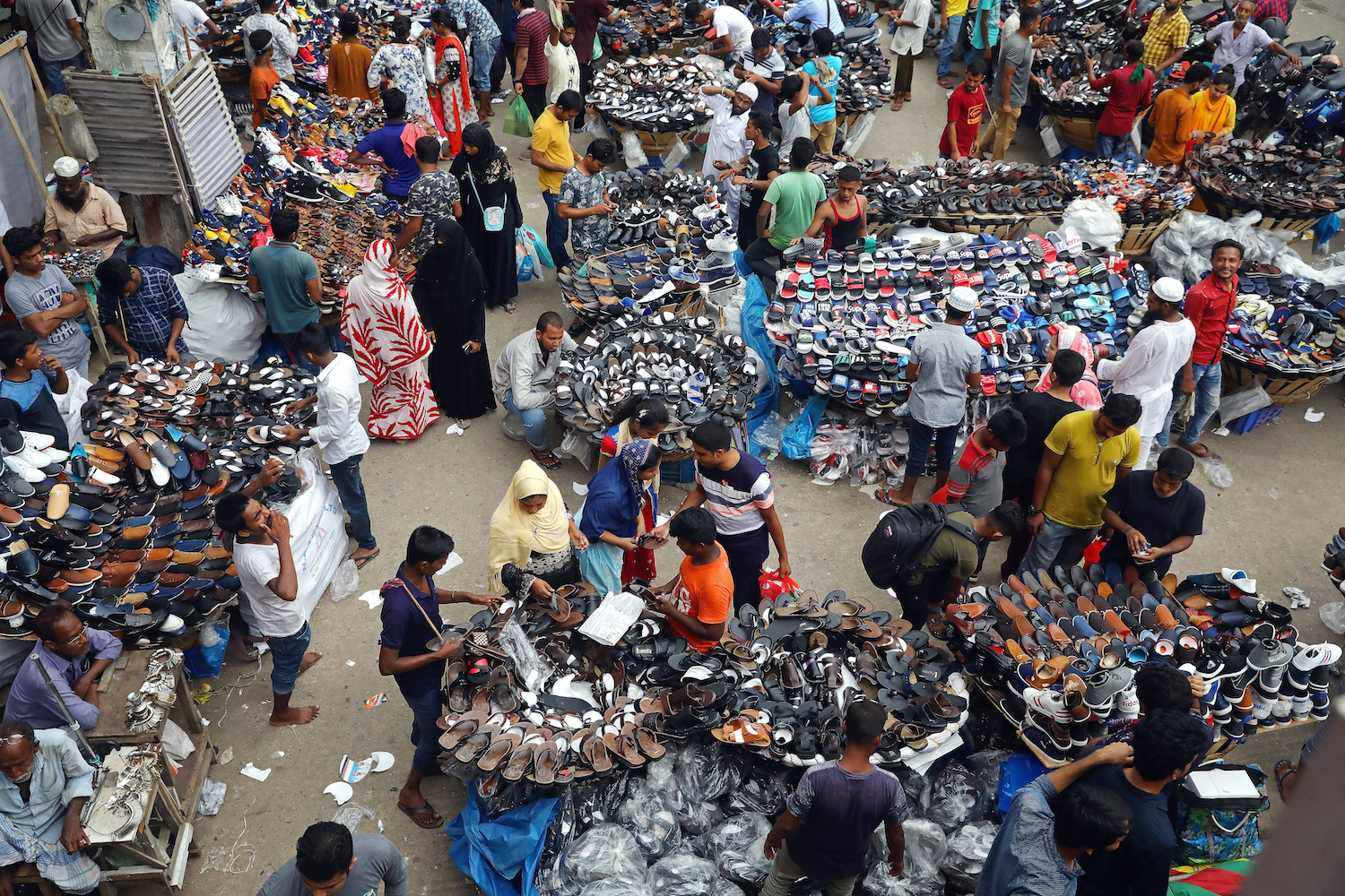 People gather at a street shoe market in Dhaka. Photo: Reuters