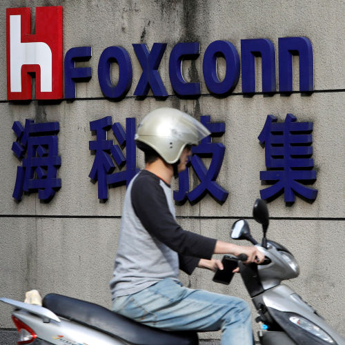 A motorcyclist rides past the logo of Foxconn in Taipei