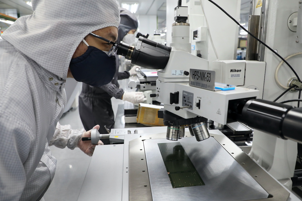 A worker inspects semiconductor chips at the chip packaging firm Unisem (M) Berhad plant in Ipoh. The US imposed sweeping chip curbs it against China in October