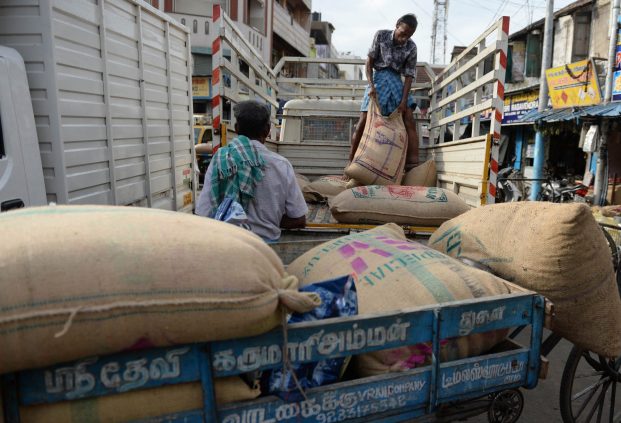 Indian worker load a truck with goods at a whole sale market in Chennai on June 29, 2017. India is bracing for upheaval as it storms ahead with its most ambitious reform in decades -- transforming the world's fastest growing major economy into a single market for the first time. The long-awaited goods and services tax (GST) rolls out July 1 even as businesses complain they are ill-prepared for the massive changes about to ripple through India's unwieldy, $2 trillion economy. ARUN SANKAR / AFP