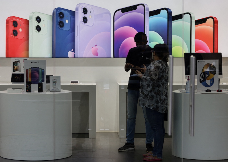 A salesperson speaks to a customer at an Apple reseller store in Mumbai