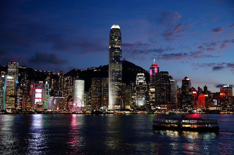 A ferry boat crosses Victoria Harbour during sunset in Hong Kong