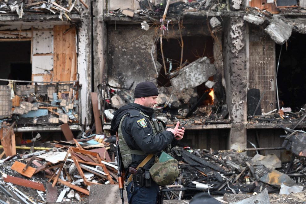 Russia Ukraine war: A police officer stands guard at a damaged residential building at Koshytsa Street, a suburb of the Ukrainian capital Kyiv, where a military shell allegedly hit, on February 25, 2022. - Invading Russian forces pressed deep into Ukraine as deadly battles killed dozens and forced hundreds to flee for their lives. AFP Photo