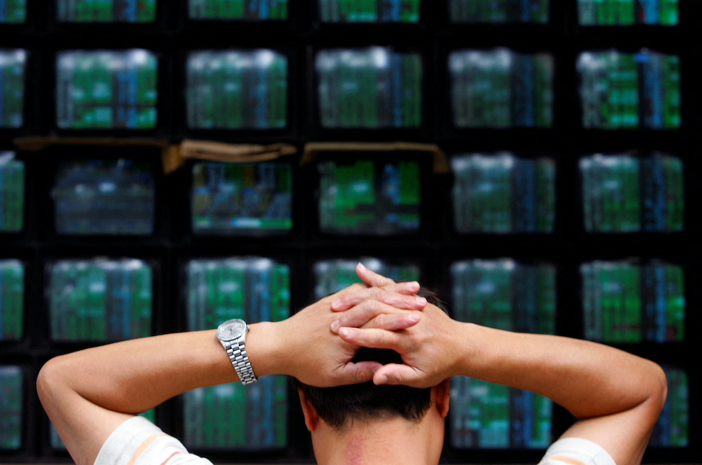 A trader looks at stock market monitors in Taipei. Photo: Reuters