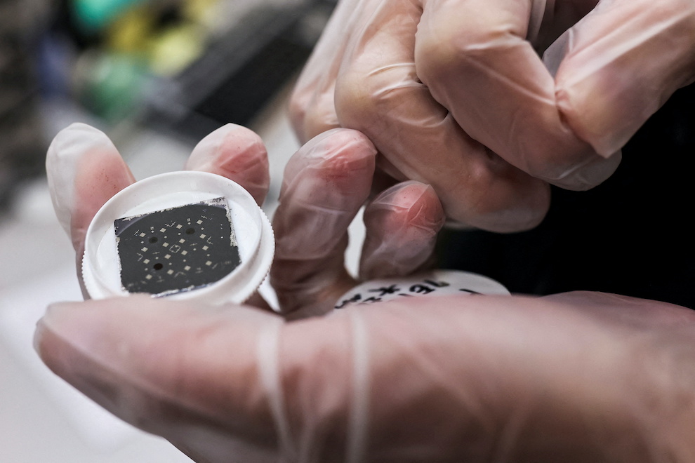 An engineer holds a chip while posing for a photo, he is in the middle of testing reactions from different materials and shapes that can have on the chip at the Taiwan Semiconductor Research Institute (TSRI) in Hsinchu