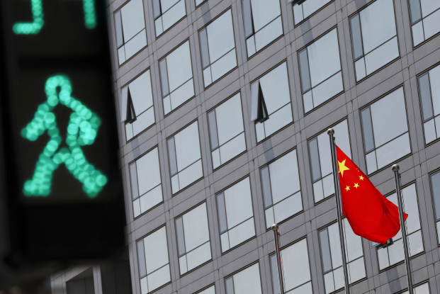 A Chinese flag flutters outside the China Securities Regulatory Commission building. Regulators' new rules may be deterring startups from launching IPOs.