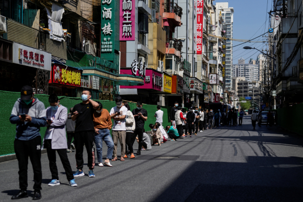 Residents stand on a street waiting for nucleic acid test