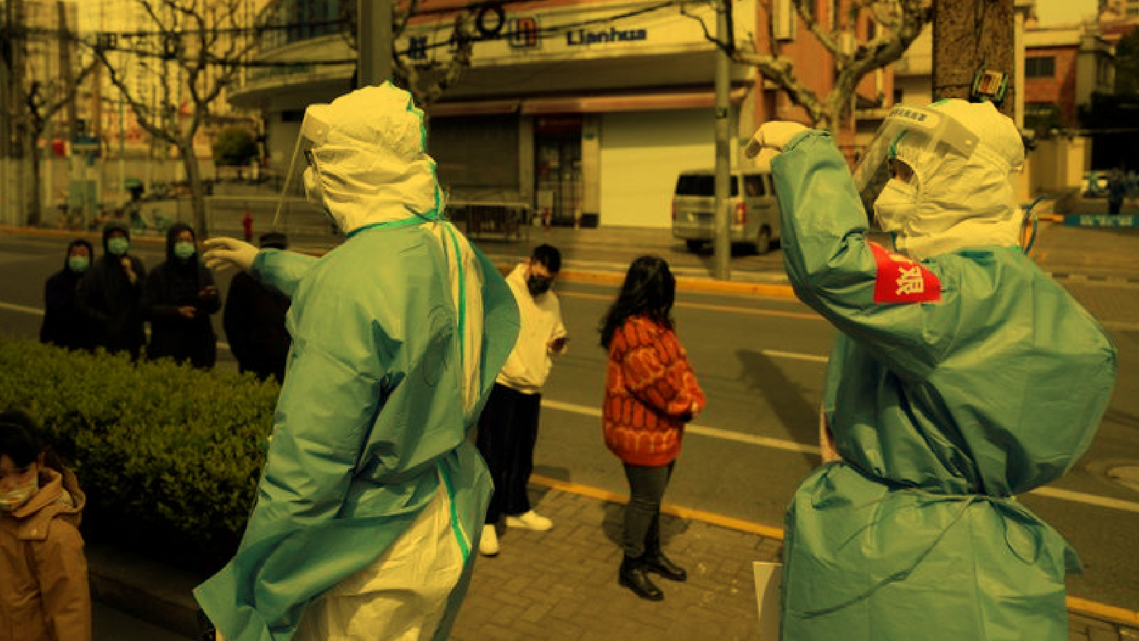 Workers in protective suits are seen next to residents lining up for nucleic acid testing, as the second stage of a two-stage lockdown to curb the spread of the coronavirus disease (COVID-19) begins in Shanghai, China April 1, 2022. Reuters