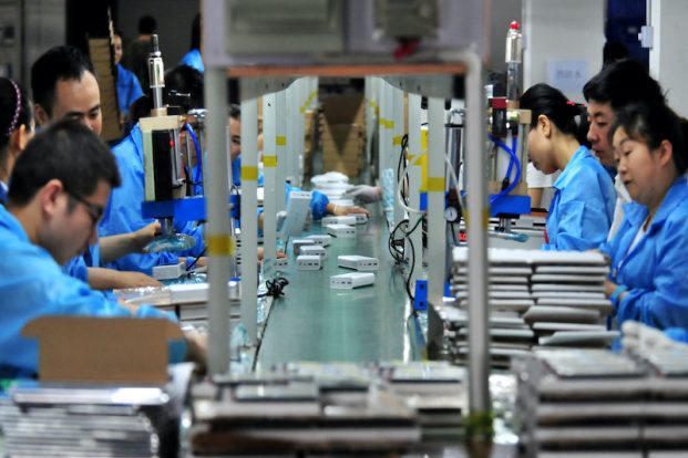 Employees work on a production line making lithium battery products at a factory in Hubei, China