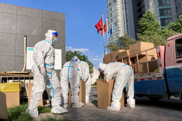 Workers sort medical waste from a makeshift nucleic acid testing site in Beijing