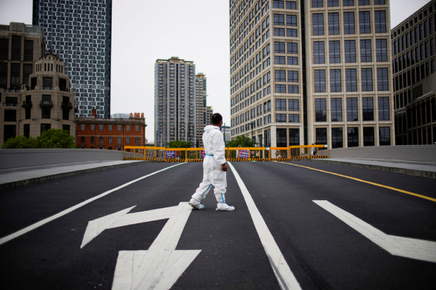 A worker in a protective suit is seen in Shanghai, which is slowly returning to reopening after its seven-week lockdown.