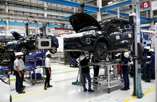 Workers inspect Tata Nexon electric sport utility vehicles at a Tata Motors plant in Pune