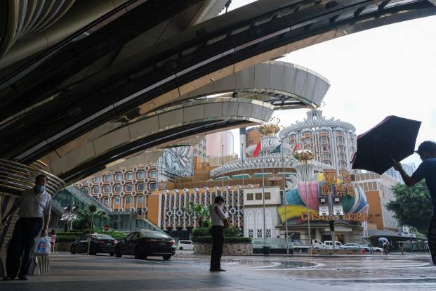 People stand near Casino Lisboa in Macao