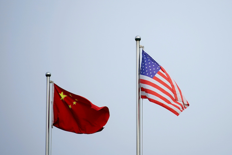 Chinese and US flags flutter outside a company building in Shanghai, China