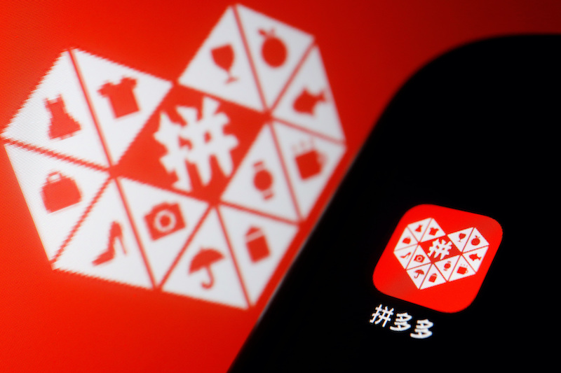 The logo of Chinese e-commerce platform Pinduoduo Inc. is displayed next to a mobile phone, in this illustration picture taken on March 22, 2022. Photo: Reuters