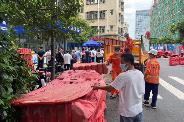 Workers set up barricades outside an entrance to Wanxia urban village as part of coronavirus disease control measures in Shenzhen, in China's Guangdong province on Monday.