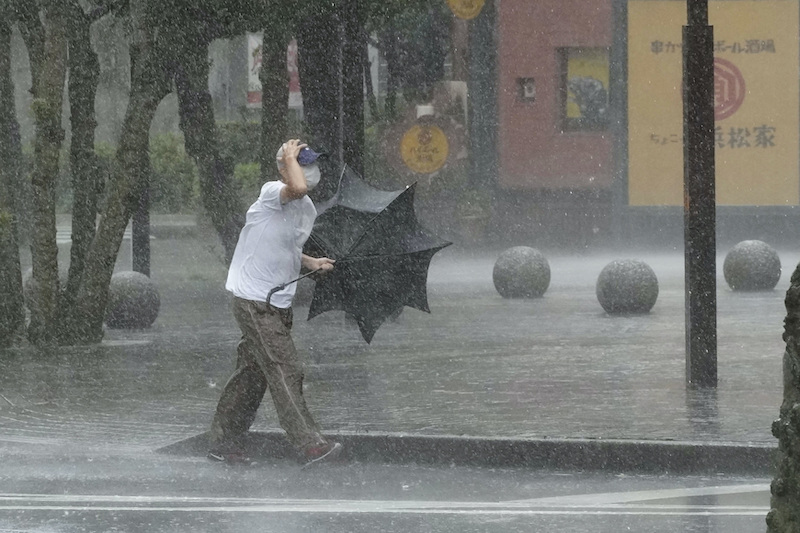 A man walks on the street in the heavy rain caused by Tropical Storm Meari in Hamamatsu, central Japan August 13, 2022, in this photo taken by Kyodo. Mandatory credit Kyodo via REUTERS