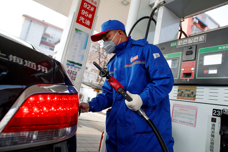 A pump attendant wears a mask as he refuels a car at a Sinopec gas station where customers can buy supplies as the country is hit by an outbreak of the novel coronavirus, in Beijing, China, February 28, 2020. REUTERS/Thomas Peter/File Photo