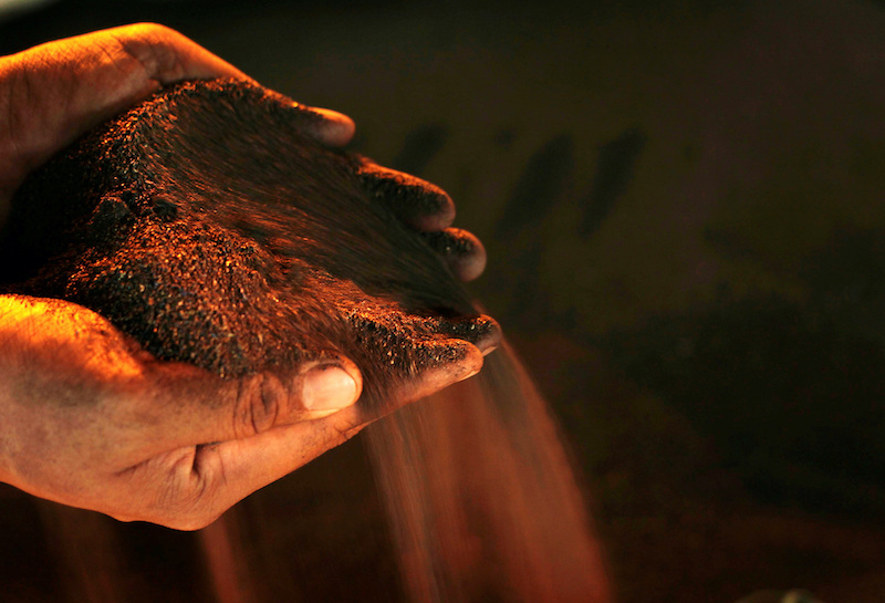 A worker poses with a handful of nickel ore at the nickel mining factory of PT Vale Tbk, near Sorowako, Indonesia, January 8, 2014. REUTERS/Yusuf Ahmad