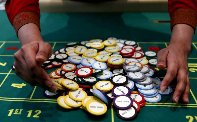 A casino dealer collects chips at a roulette table in Pasay city, Metro Manila, Philippines, March 27, 2015. REUTERS/Erik De Castro