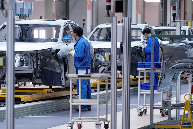 Employees work on an assembly line at a SAIC Volkswagen plant in Shanghai