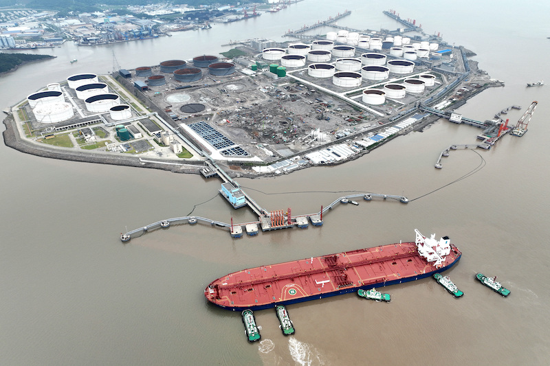 An aerial view shows tugboats helping a crude oil tanker to berth at an oil terminal, off Waidiao Island in Zhoushan, Zhejiang province, China July 18, 2022. cnsphoto via REUTERS