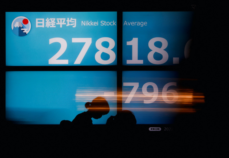 People walk past an electric board showing Japan's Nikkei share average in Tokyo, Japan September 14, 2022. REUTERS/Issei Kato