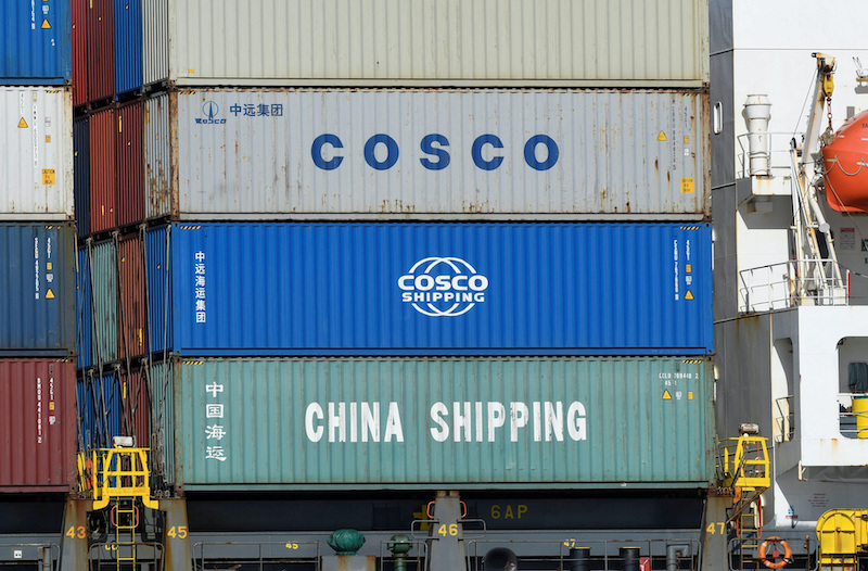 Containers of COSCO (China Ocean Shipping Company) and other firms are loaded on a ship at the port in Hamburg