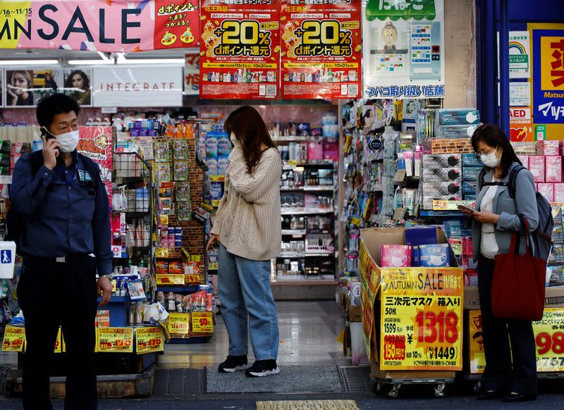 People consider products at a drug store in Tokyo