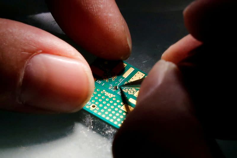A researcher plants a chip on an interface board at Tsinghua Unigroup research centre in Beijing