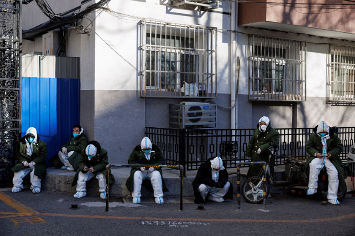Pandemic control workers in protective suits sit in a neighbourhood that used to be under lockdown, as coronavirus disease (COVID-19) outbreaks continue, in Beijing, China December 10, 2022