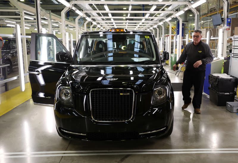 A worker is seen by the electric taxi production line in the London Electric Vehicle Company factory in Coventry.