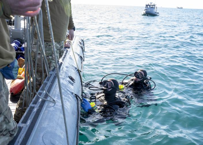 Sailors conduct pre-dive checks during recovery efforts of a high-altitude balloon in the Atlantic