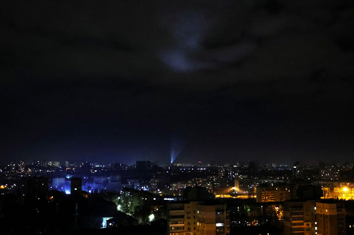 Ukrainian servicemen use searchlights as they search for drones in a sky over city during a Russian drones strike in Kyiv, Ukraine