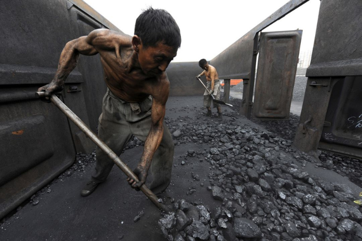 Workers unload coal at a railway station in Hefei, Anhui province