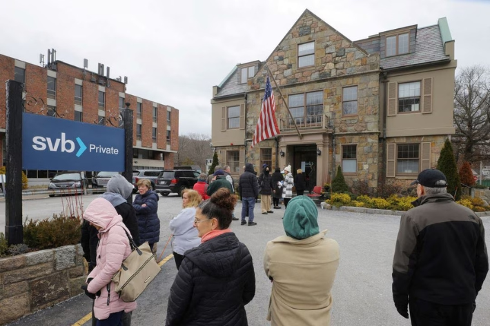 Customers wait in line outside a branch of the Silicon Valley Bank (SVB), after its collapse, in Wellesley, Massachusetts, US