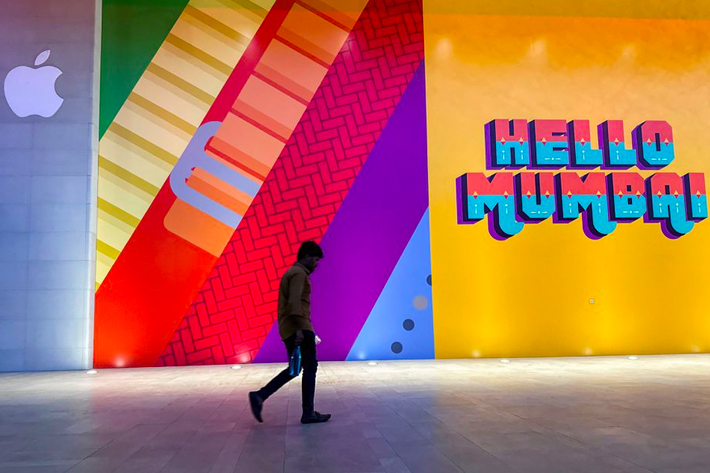 A man walks past the barricade of India's first Apple retail store, that will be launched soon, at Jio World Drive Mall, Mumbai, India