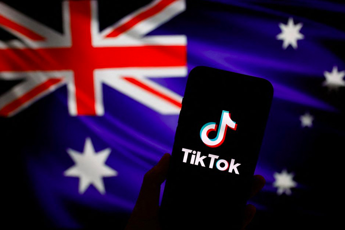 The logo of Chinese-owned video app TikTok is seen on a smartphone in front of an image of the Australian national flag