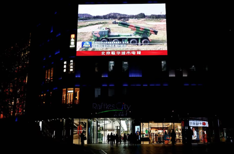 A giant screen displays a broadcast of news footage of military vehicles under the Eastern Theatre Command of China's People's Liberation Army (PLA) taking part in a combat readiness patrol and "Joint Sword" exercises around Taiwan in China, at a shopping mall in Beijing, China April 10, 2023. REUTERS/Tingshu Wang/File Photo