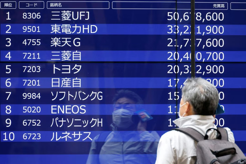 A man is reflected on an electric monitor displaying a stock quotation board outside a bank in Tokyo, Japan, June 5, 2023. REUTERS/Issei Kato/ FILE PHOTO