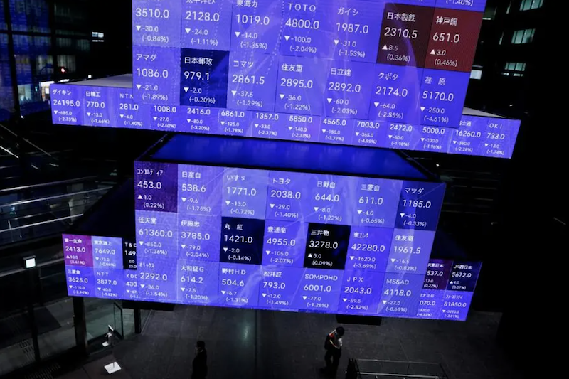 Visitors walk past Japan's Nikkei stock prices quotation board inside a conference hall in Tokyo, Japan September 14, 2022. REUTERS/Issei Kato