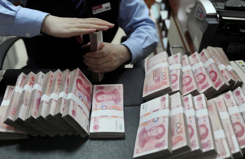A bank employee counts 100 yuan notes in China's Hefei. photo: Reuters