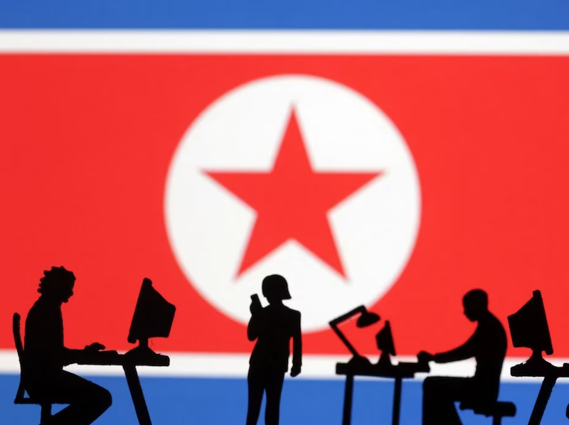 Miniatures of people with computers are seen in front of North Korea flag in this illustration taken July 19, 2023. REUTERS/Dado Ruvic/Illustration