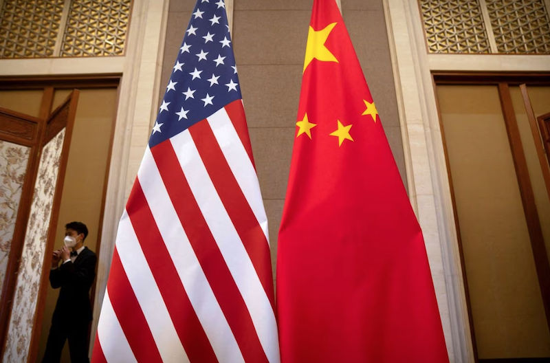 A staff member wearing a face mask walks past United States and Chinese flags set up before a meeting between Treasury Secretary Janet Yellen and Chinese Vice Premier He Lifeng at the Diaoyutai State Guesthouse in Beijing, China, Saturday, July 8, 2023. Mark Schiefelbein/Pool via REUTERS/File Photo