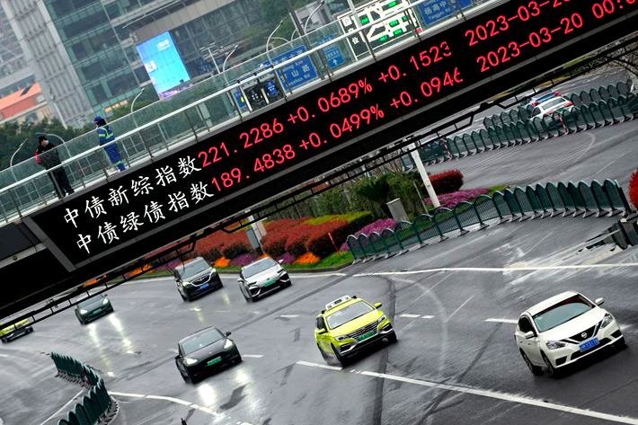 An electronic board shows stock indexes at the Lujiazui financial district in Shanghai, China