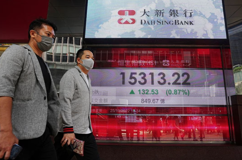 People walk past a screen displaying the Hang Seng stock index at Central district, in Hong Kong, China October 25, 2022. REUTERS/Lam Yik/File Photo Acquire Licensing Rights
