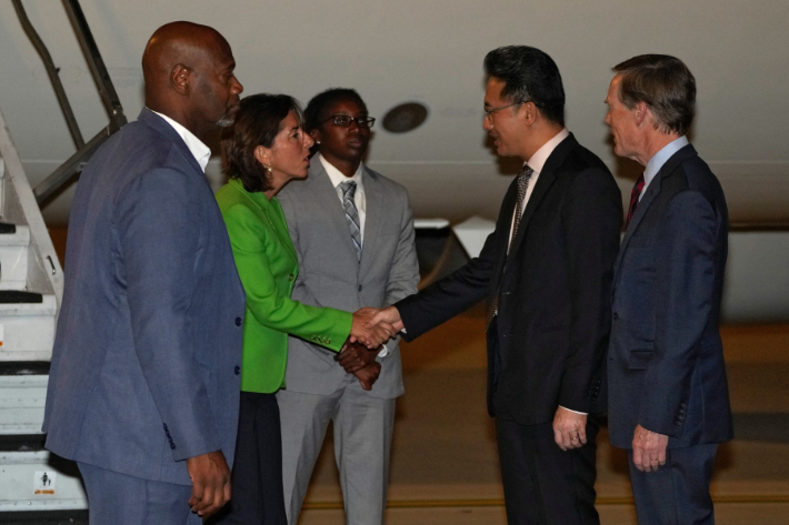 U.S. Commerce Secretary Gina Raimondo, shakes hands with Lin Feng, Director General of China Ministry of Commerce as U.S. Ambassador to China Nick Burns looks on as she arrives at the Beijing Capital International Airport in Beijing