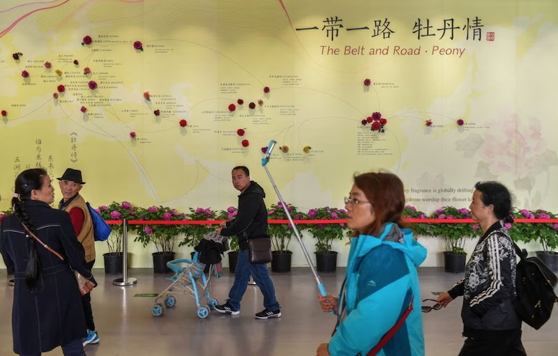 Visitors walk past a wall with a map showing the species of peony in Belt and Road Initiative (BRI) countries, at horticultural exhibition Beijing Expo 2019, in Beijing, China April 29, 2019. Picture taken April 29, 2019. REUTERS/Stringer/file photo Acquire Licensing Rights